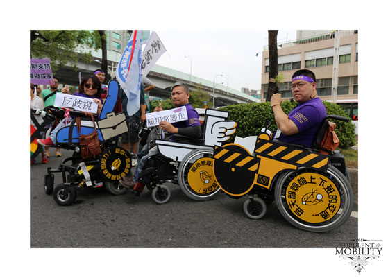 Three wheelchair riders pose with signs in Taiwanese. The chairs are decorated as an office chair with a briefcase, an accessible toilet, and an accessible vehicle.