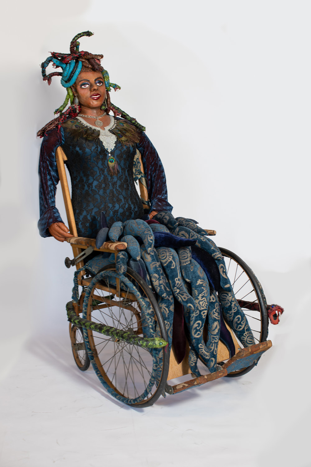 A sculpted female figure with snakes for hair built into a vintage wheelchair