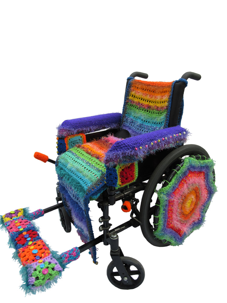 A wheelchair covered in brightly colored crocheted yarns.