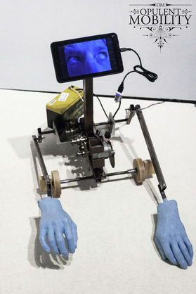 A robot crawler with blue rubber hands and a video screen for eyes.
