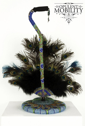 A bejeweled cane and stand with a peacock feather fan base