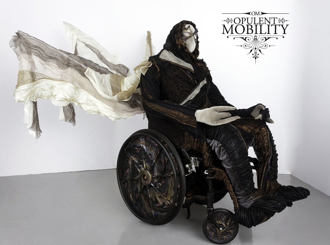 A manual wheelchair with black and gold swirled wheels, a billowing sail, and a masked rider in black, copper, and silver to match the chair.