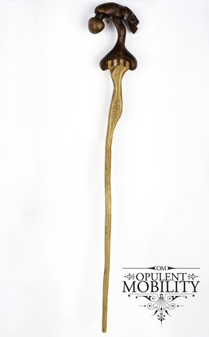 A wooden cane with a handle carved in the shape of a woman's head