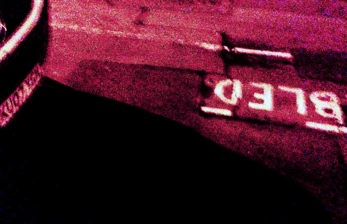 a blurry red photo of a back car bumper and the word 