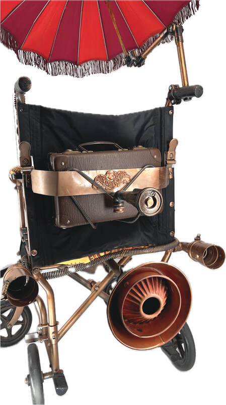 Back view of a wheelchair with attached brass and leather accessories and a fringed red parasol