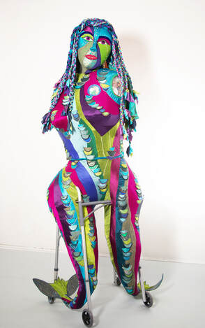 A large, multi-colored sculpture of a woman with fishtails for legs built into a walker.